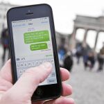Un smartphone en red ante la Puerta de Brandenburgo de Berlín