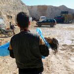 Un hombre el cuerpo sin vida de un niño tras el ataque con armas químicas