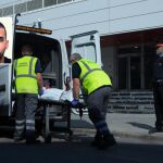 Miembros del servicio judicial retiran el cadáver del hombre que ha sido abatido esta mañana al intentar acceder a la comisaría de los Mossos de Cornellà con un cuchillo en la mano/Efe