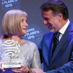 La escritora recoge el premio de manos de José Crehueras