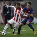 Denis Suárez (d) de FC Barcelona disputa un balón con Diogo Figueiras (i) de Olympiacos