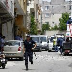 Un oficial de policía corre después de que dos misiles golpearan la ciudad kurda de Kilis cerca de la frontera siria, ayer