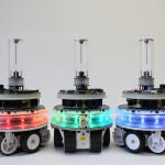 Tres robots autónomos con iluminación LED en diferentes colores