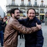 Los líderes de Podemos, Pablo Iglesias (d), y de IU, Alberto Garzón (i), dándose un abrazo en la Puerta del Sol