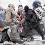 Combatientes rebeldes ayudan a un hombre herido por la explosión de un coche bomba, ayer en Jub al Barazi, al norte de Al Bab