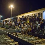 Decenas de inmigrantes esperan en las vías de tren junto a la frontera croata.