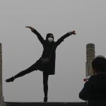 Una mujer posa para una foto mientras usa una mascarilla para protegerse contra la contaminación ambiental durante una visita al Templo del Cielo de Pekín (China), el pasado 8 de diciembre
