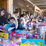 Numeroso público visitan a algunas de las librerías instaladas en los soportales de la Plaza Mayor
