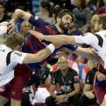 Raúl Entrerríos (c), del FC Barcelona Lassa, intenta lanzar ante la defensa Steffen Weinhold (i) y Christian Sprenger, del THW Kiel, durante el partido