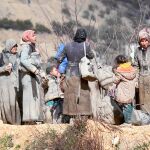 Familias de refugiados buscan dónde acampar al aire libre a la espera de obtener el permiso para cruzar a Turquía desde Siria