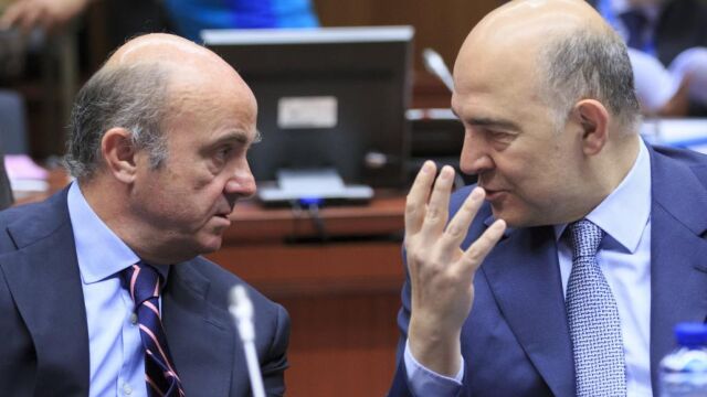 Luis de Guindos conversa con el comisario europeo de Asuntos Económicos y Financieros, Pierre Moscovici