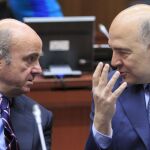Luis de Guindos conversa con el comisario europeo de Asuntos Económicos y Financieros, Pierre Moscovici