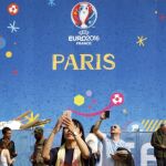Varias personas visitan la zona de aficionados instalada junto a la torre Eiffel, en París