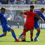 El centrocampista de la Real Sociedad Xabi Prieto (c) disputa un balón con los jugadores del Getafe Mauro Arambarri (i) y Juan Cala (d) durante el partido correspondiente a la décima jornada de LaLiga Santander.