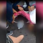 La mujer en el suelo con su bebé todavía en los brazos