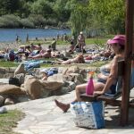 Varias personas disfrutan del buen tiempo en la zona fluvial del río Miño y las termas de A Chavasqueira