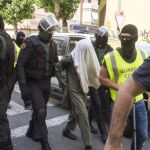 Miembros de la Guardia Civil custodian a uno de los tres hermanos pakistaníes detenidos en el barrio de Pardinyes