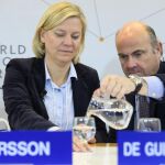 Luis de Guindos sirve agua a su homóloga sueca, Magdalena Andersson, durante la cumbre de Davos