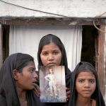 Las hijas de Asia Bibi posan con una foto de su madre en 2010, poco después de su detención