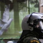 Cada uno de los policías apostados ante el palacio gubernamental sostenía un pedazo de tela negra en el que en letras blancas aparecían frases de protesta.