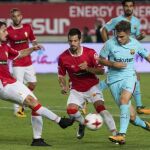 El centrocampista del F.C Barcelona Denis Suárez (d) intenta llevarse el balón ante los jugadores del Real Murcia, Antonio Escribano (i) y Pedro Orfila
