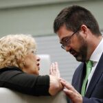 El ex concejal de Economía y Hacienda de Ahora Madrid, Carlos Sánchez Mato, conversa con la ex alcaldesa de Madrid, Manuela Carmena, durante un pleno en el Ayuntamiento de Madrid
