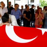 Un familiar de Gulsen Bahadir, una de las víctimas del atentado, llora sobre el féretro cubierto con la bandera turca