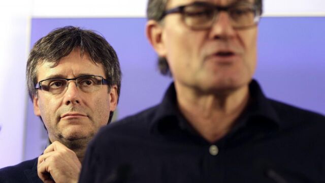 El presidente de la Generalitat, Carles Puigdemont (i), escucha al presidente de CDC, Artur Mas, tras el anuncio de los resultados del "supersábado", el 21 de mayo