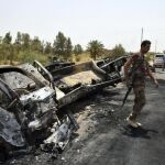 Fotografía facilitada hoy, 30 de junio de 2016, que muestra a un soldado iraquí mientras inspecciona ayer varios camiones de Estado Islamico calcinados tras un fuerte enfrentamiento en al sudoeste de Faluya (Irak)