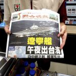 Un dependiente taiwanés muestra la portada del periódico «United Evening News» con la imagen de un portaviones chino cruzando el estrecho de Taiwán