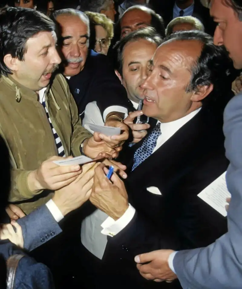El fundador de Rumasa durante un acto público firmando autógrafos, y Ruiz-Mateos
