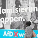 Una mujer musulmana camina ante un cartel antiinmigración del partido ultraderechista Alternativa para Alemania