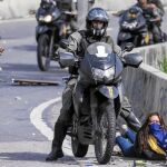 La guardia bolivariana es el brazo ejecutor de la política represiva de Maduro. Aquí un agente pisotea a una joven en Caracas