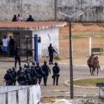 Dos presos ayudan otro reo herido durante una rebelión en la prisión de Alcaçuz