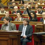 El presidente de la Generalitat, Carles Puigdemont (c), durante la votación en el pleno del Parlamento catalán sobre a moción de la CUP pactada con Junts pel Sí