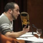 David Fernández con su sandalia en la mano en 2013