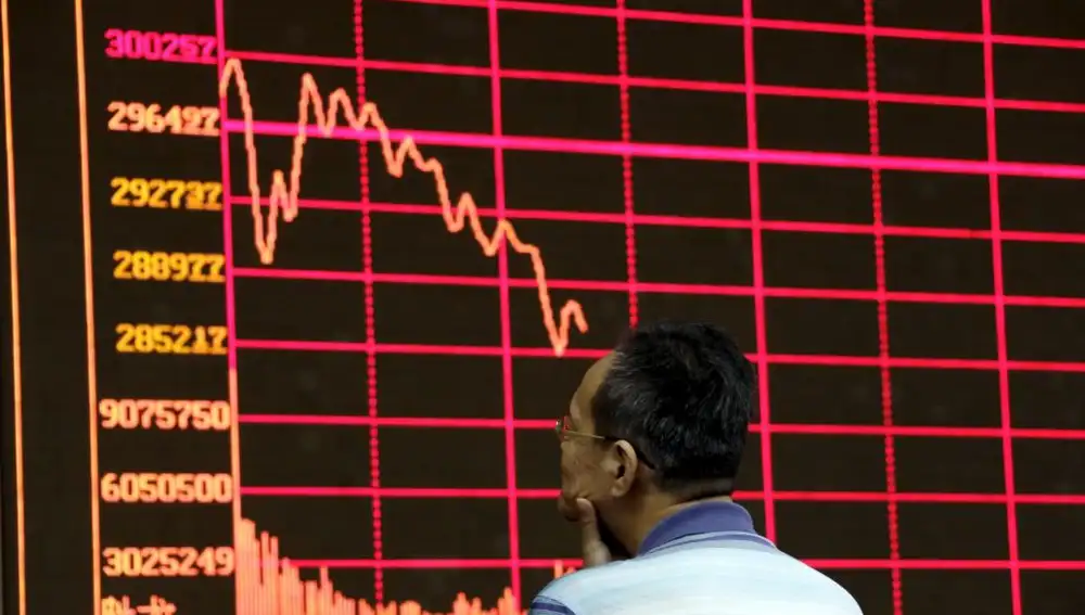 Un inversor analiza uno de los panales informativos de la Bolsa de Shanghai