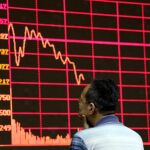 Un inversor analiza uno de los panales informativos de la Bolsa de Shanghai