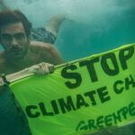 El actor buceando con una pancarta de Greenpeace