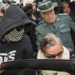 El Cuco, con la cabeza y la cara tapadas, acompañado por su madre, intentan entrar en un coche tras el juicio por incumplir la orden de alejamiento de la familia de Marta.