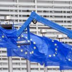 Un trabajador arregla una de las banderas de la sede de la Unión Europea en Bruselas el 23 de julio, día del referéndum británico