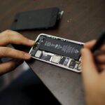 Un trabajador trata de reparar un iPhone en una tienda de Nueva York