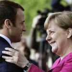 La canciller alemana Angela Merkel (i) y el presidente francés Emmanuel Macron (d) antes de la rueda de prensa tras su encuentro en la cancillería alemana en Berlín.