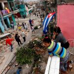 La gente observa mientras otros pasan junto a los escombros después de que el tornado arrasara un barrio en La Habana / Reuters