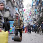 Familias de Alepo, al norte de Siria, transportan los escasos suministros que aún quedan en la ciudad asediada por la ofensiva sirio-rusa