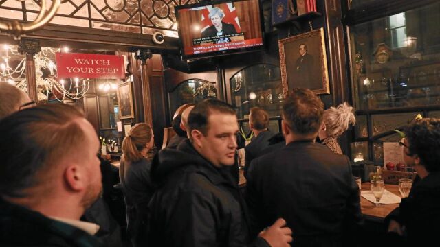 Clientes siguen en el pub Red Lion de Londres la comparecencia de May del jueves en la que defendió su permanencia en el Gobierno tras una cascada de dimisiones