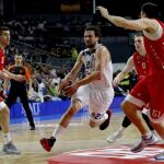 El base del Real Madrid, Sergio Llull (c), entra a canasta ante la defensa del Estrella Roja de Belgrado