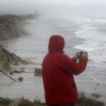 La playa del El Saler comida por un temporal. Al fondo, las grúas del Puerto de Valencia
