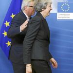 El presidente de la Comisión, Jean Claude Juncker, da una palmada a la primera ministra británica, Theresa May, a su llegada a la sede europea, ayer