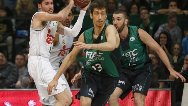 El alero del Real Madrid, Rudy Fernández (i), controla la pelota ante la oposición de José Ignacio Nogués (c), del Joventut, durante el partido